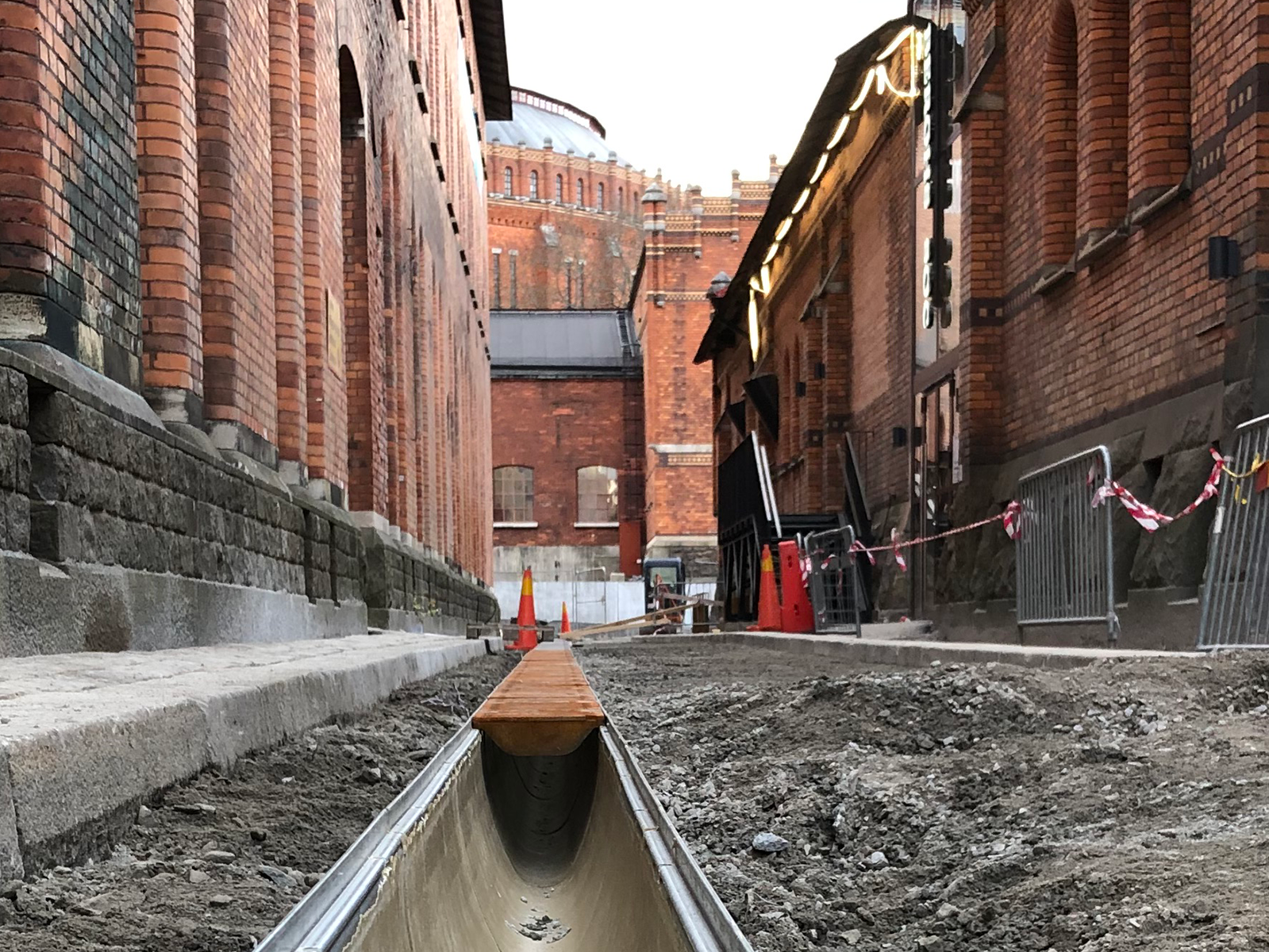 En markränna installeras i en smal gränd.