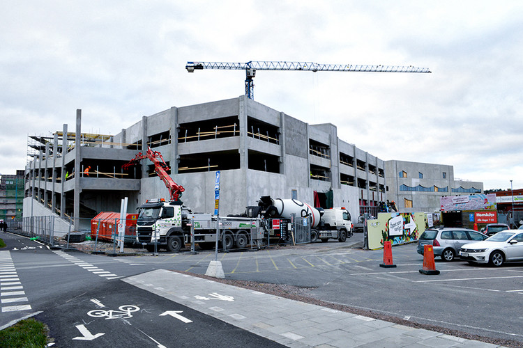 En stor byggnad under konstruktion med en kran i bakgrunden.