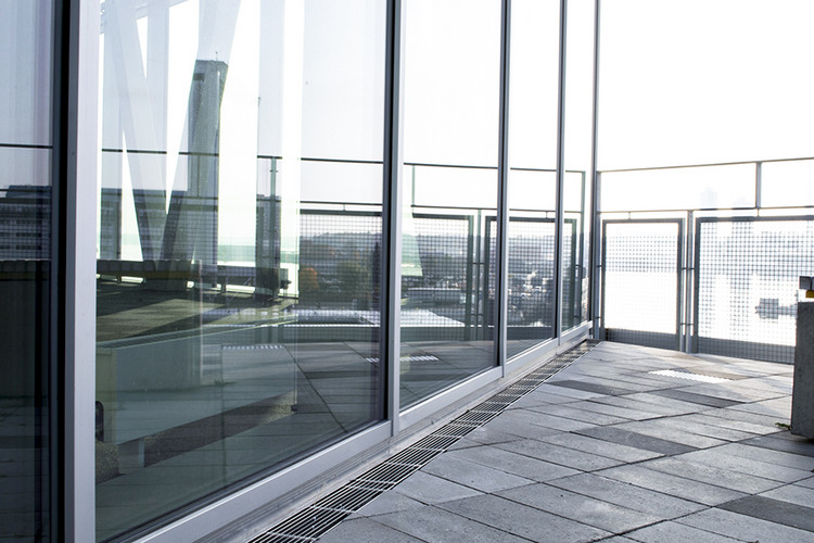 Hamnterminal med marksten, markrännor med och stora fönsterglas.