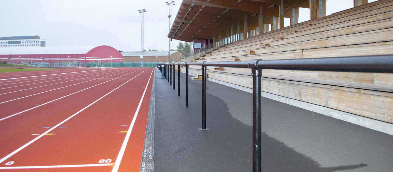 Friidrottsarena med löparbanor samt sittplatser under tak.