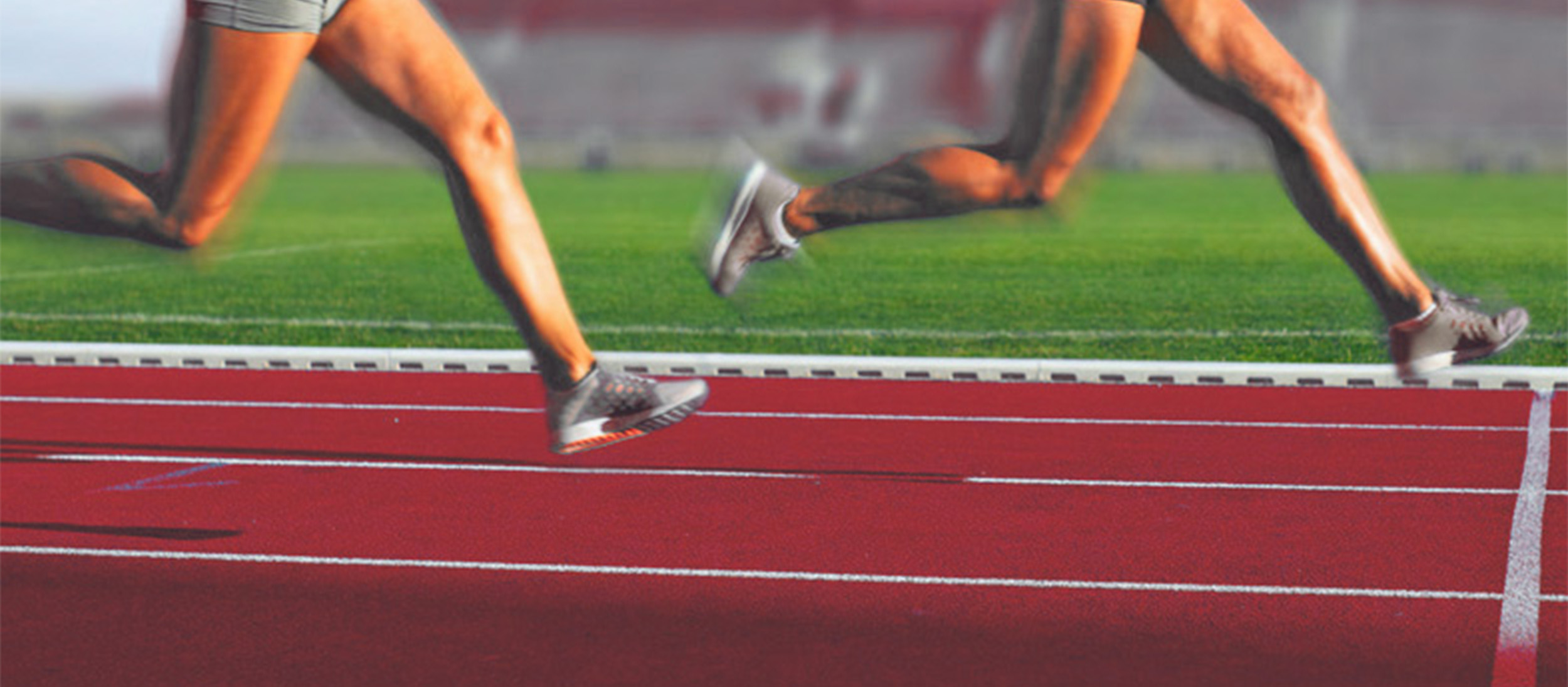 Två tjejer tävlar på röd löparbana.